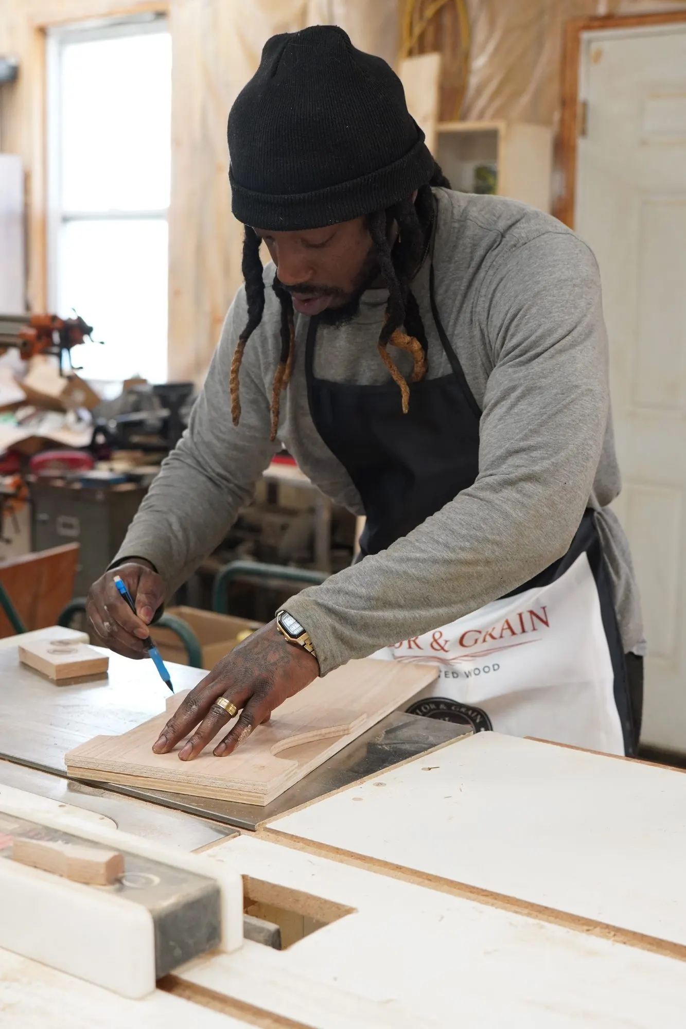 Maker marking a plywood stool template at the table saw
