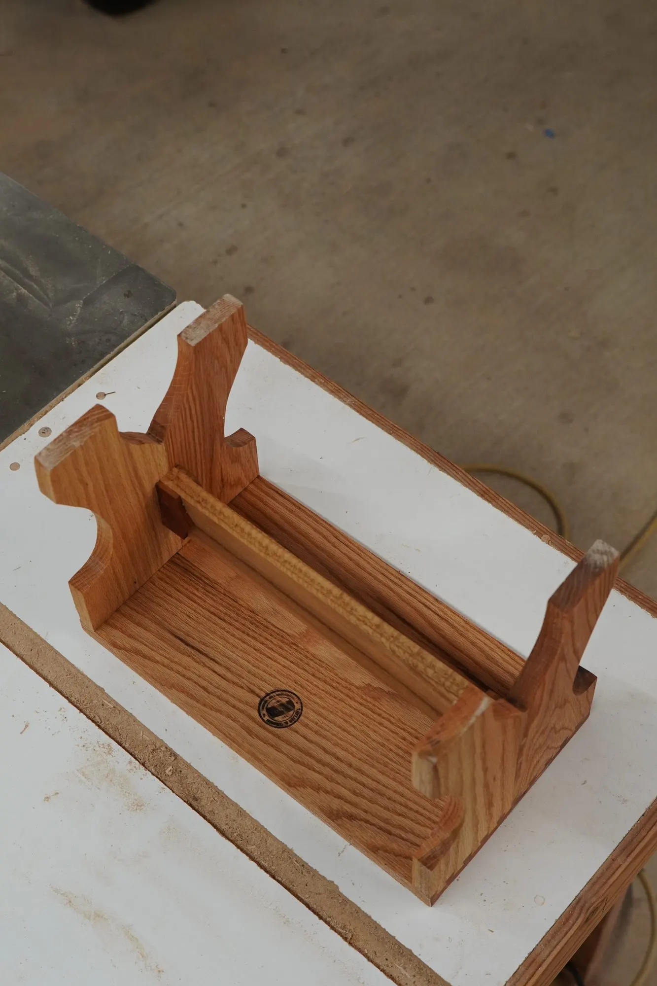 Small oak stand with shaped uprights and a Taylor and Grain stamp on the base