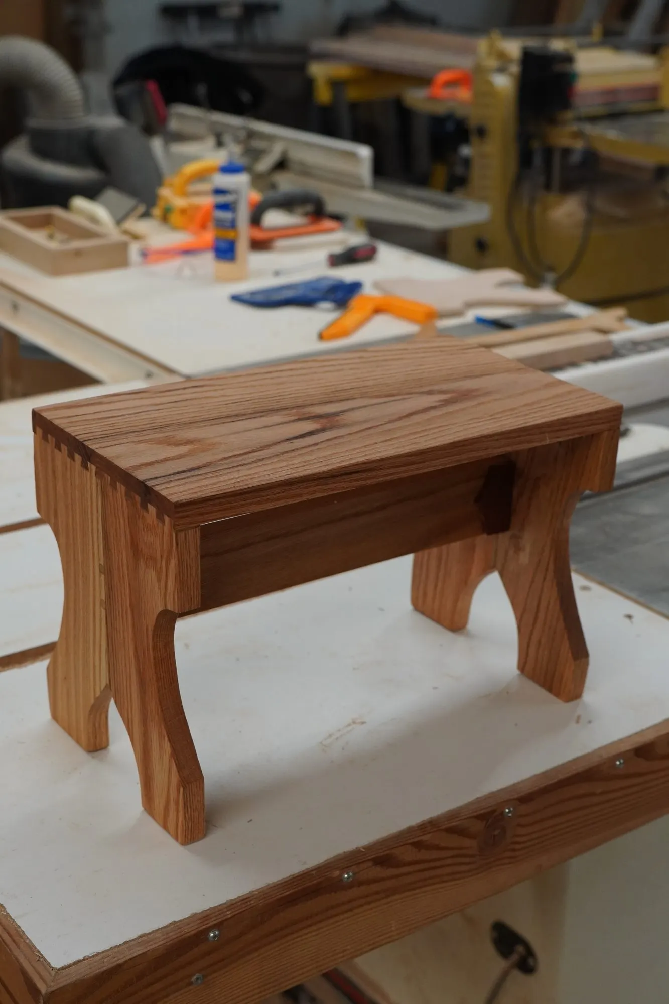 Finished red oak stool with dovetail corners on the Taylor and Grain workbench